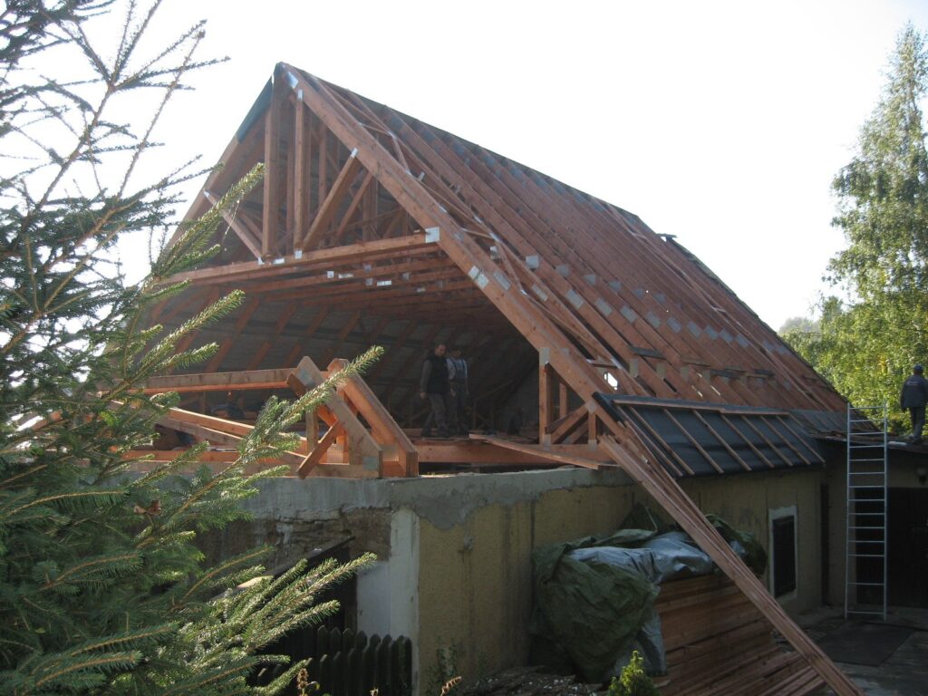 Detail příhradových vazníků proti modré obloze – Srní, Atelier dřevostaveb.